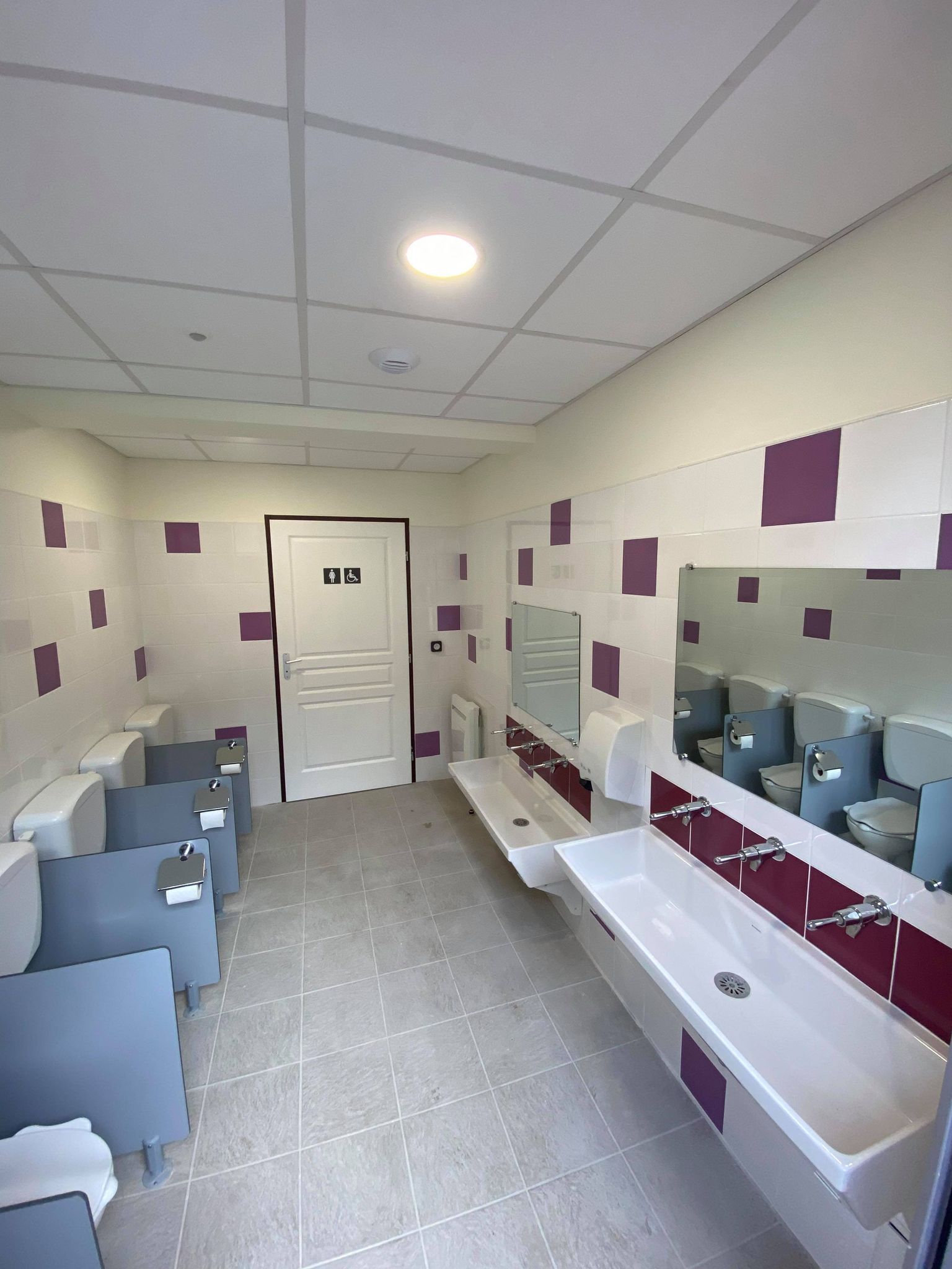 Sanitaires collectifs avec rangée de toilettes en bâtiment public
