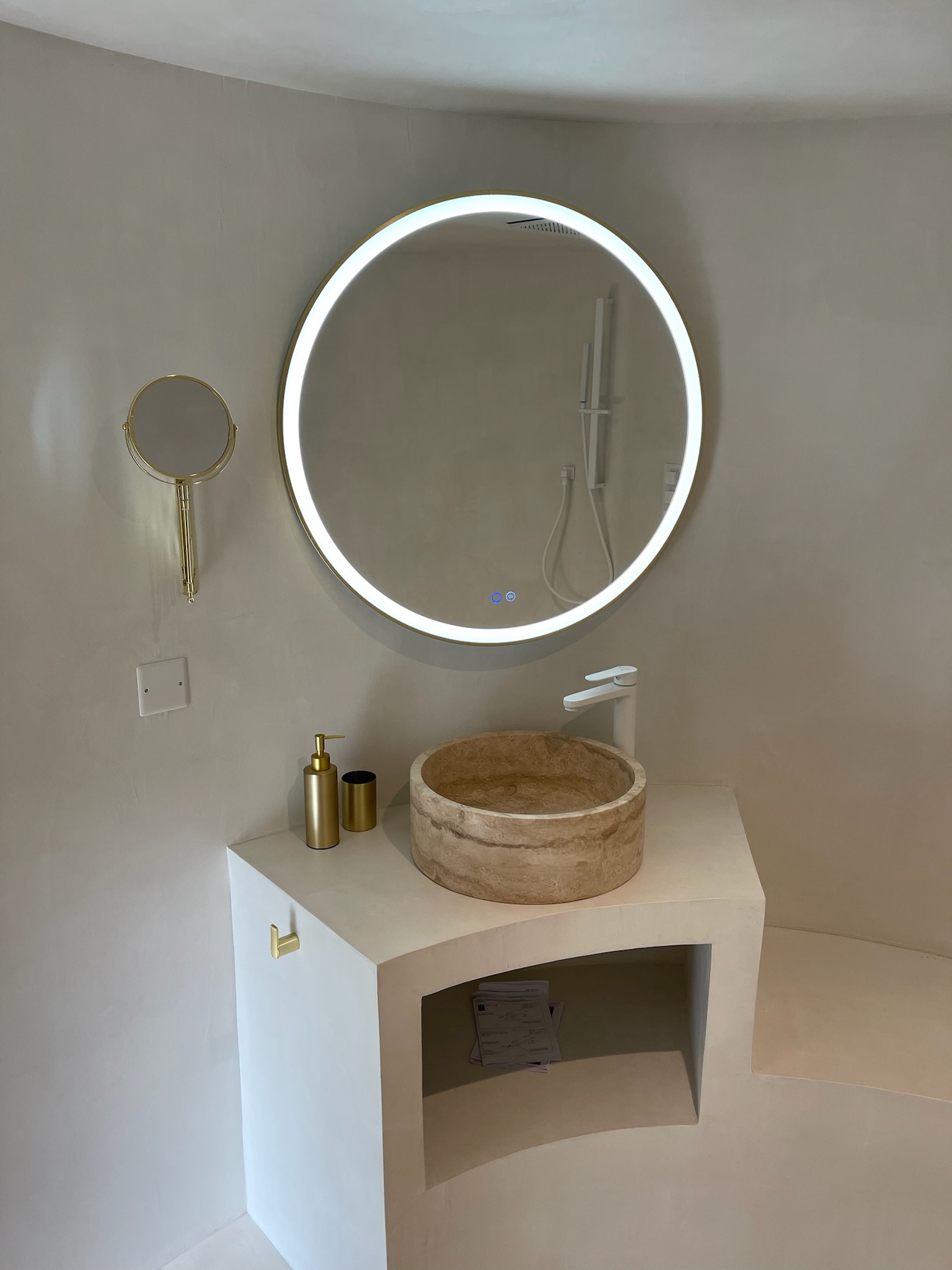 Salle de bain enduit chaux, vasque en travertin et miroir LED rond