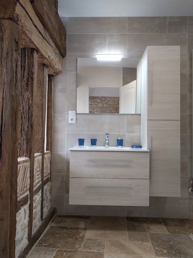 Salle de bain rustique avec poutre apparente et meuble vasque clair
